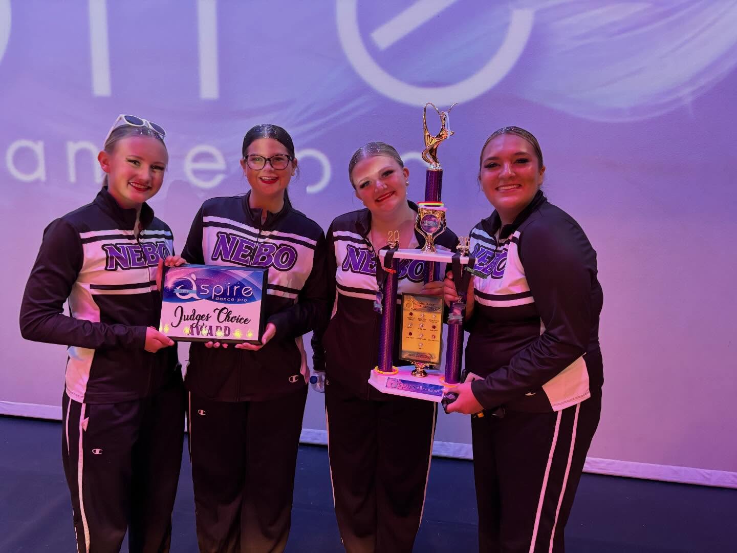 Competitive team holding a Judges Choice award and grand champion trophy